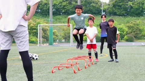Japanese Boy Jumping Over Agility Hurdles During Soccer Training Stock-Footage 344240696