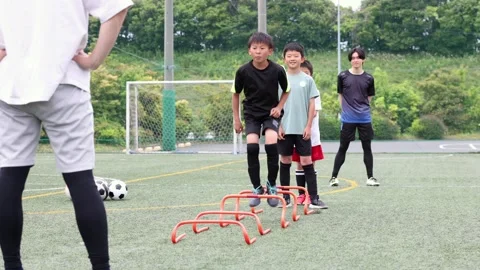 Japanese Boy Jumping Over Agility Hurdles During Soccer Training Stock-Footage 344240735