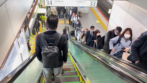 Japanese Businessman with Backpack Riding Down Escalator Stock Footage 331504086