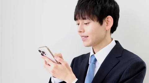 Japanese Businessman Using Smartphone Against White Background Stock Footage 344204792