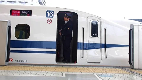 Japanese conductor inside train on platform Stock Footage 81694595