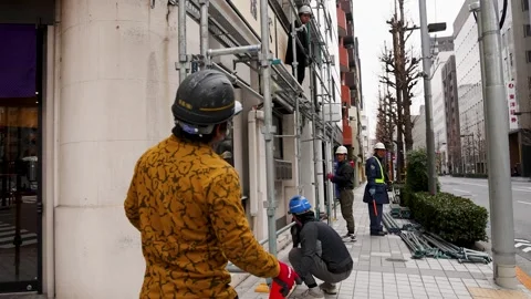 Japanese Construction Workers Assembling Scaffolding on Tokyo Sidewalk Stock Footage 342886718