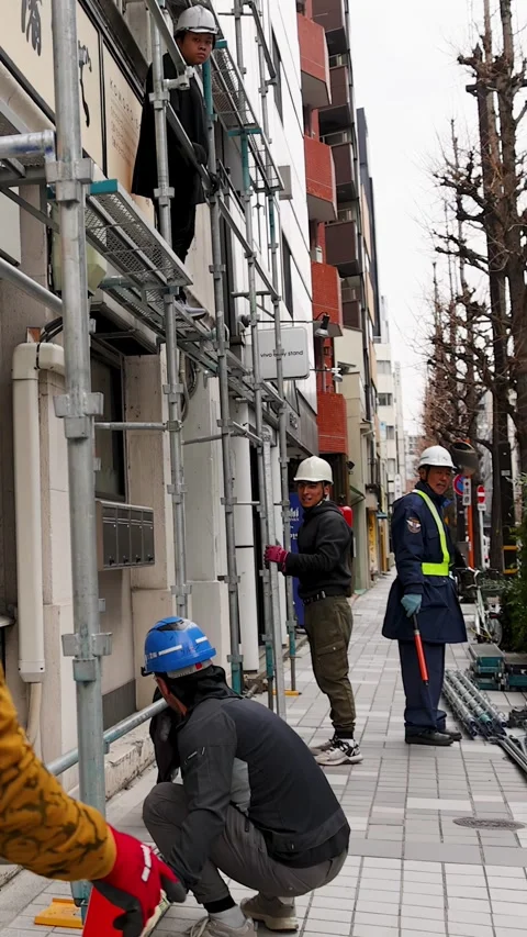 Japanese Construction Workers Assembling Scaffolding on Tokyo Sidewalk Stock Footage 344106297