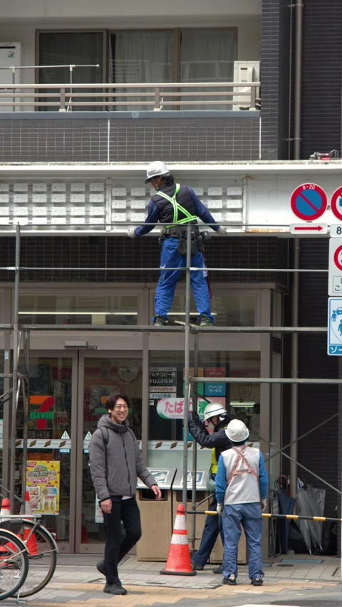 Japanese Construction Workers Performing Maintenance on Scaffolding in Tokyo Stock Footage 343593076