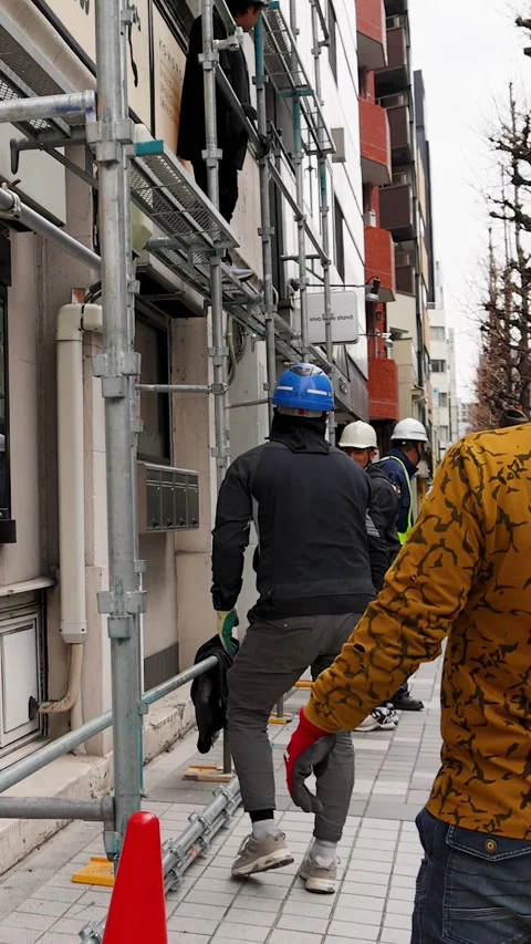 Japanese Construction Workers Setting Up Scaffolding on Tokyo Sidewalk Stock Footage 344089514