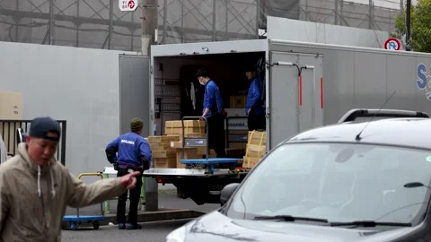 Japanese Delivery Workers Unloading Cargo Truck on Tokyo Street Stock Footage 342580404