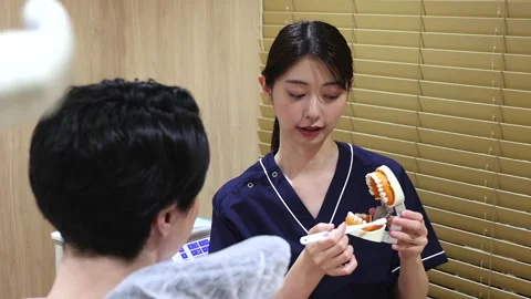 Japanese Dentist Teaching Proper Tooth Brushing with Dental Model 動画素材 343906989