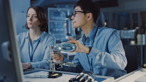 Japanese Development Engineer in Blue Shirt is Soldering a Circuit Board Stock Footage 105344326