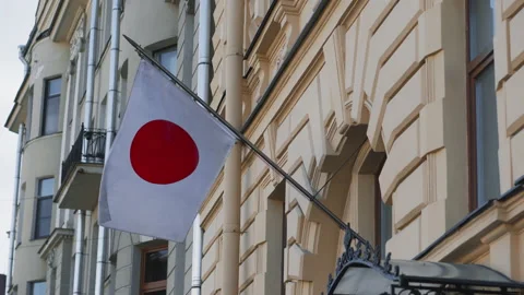The Japanese flag is developing against the background of an old yellow Stock Footage 131975928