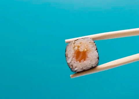 Japanese food close-up on a plain background.Sushi with chopsticks isolated  Stock Photos