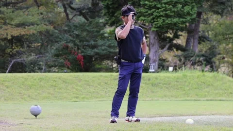 Japanese Golfer Using Laser Rangefinder to Measure Distance on Golf Course Stock-Footage 344134741
