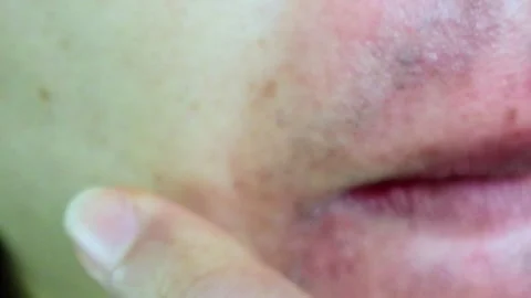 A Japanese man checking his thinning beard after hair removal Stock Footage 325694191