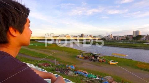 JAPANESE MAN looking at the river and thinking. Stock Photos