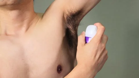 Japanese men using antiperspirant spray on their armpits Stock Footage 336639795