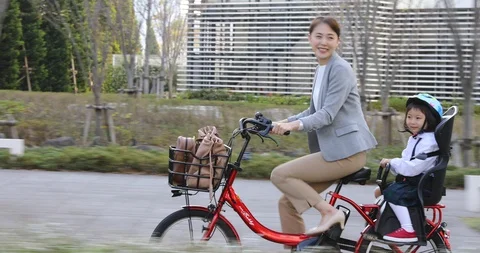 Japanese mother and daughter riding electric bike Stock Footage