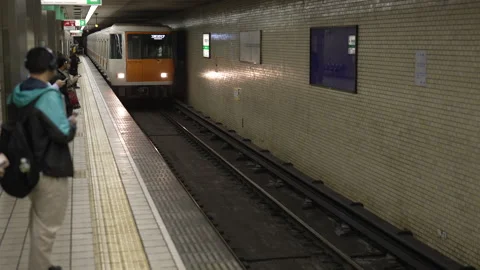 Japanese Orange Subway Train Pulling up to Station - People waiting Vídeo Stock 242603845