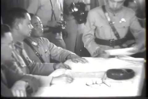 Japanese representatives sit at table and military film crew takes photos - 1945 Stock Footage 93844218