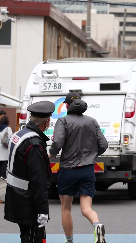 Japanese Sanitation Worker and Security Guard on Busy Tokyo Street Stock Footage 343594483