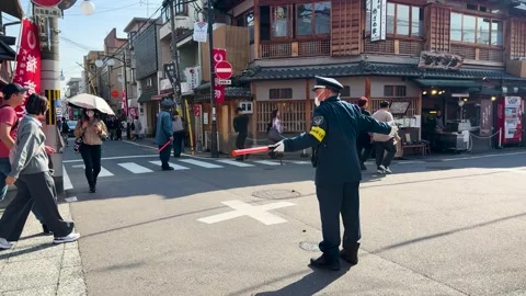 Japanese Security Guard Directing Pedestrian Traffic in Kyoto City Street Vídeos de archivo 332827708