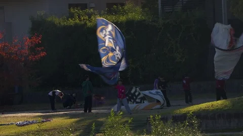 Japanese students wave huge silk flags, backlit by sunshine in Kyoto Stock Footage 325270052