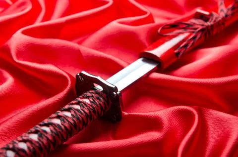 Japanese sword takana on red satin background Stock Photos