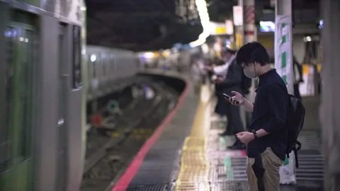 Japanese using smartphone while waiting for train at train station. Information  動画素材 244053622