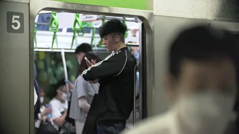 Japanese using smartphone while waiting for train at train station. Information  Stock-Footage 244053994