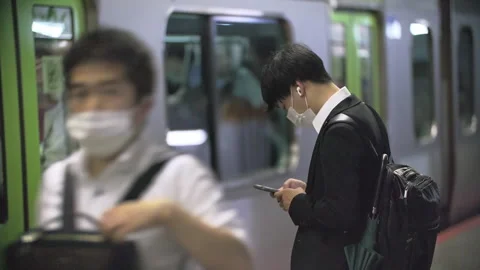 Japanese using smartphone while waiting for train at train station. Information  動画素材 244054173