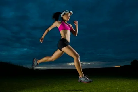 Japanese woman running at night Stock Photos