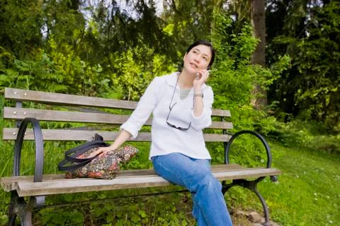 Japanese woman using cell phone in park Stock Photos