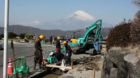 Japanese workers in Hakone work on a road with Mount Fuji in the background. 스톡 동영상 25821577