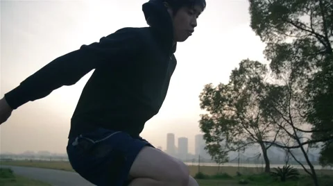 Japanese young runner warms up jumping before big run training at sunrise. Vídeo Stock 61757158
