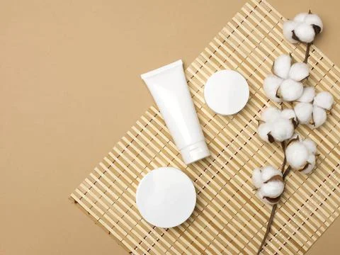 Jar and empty white plastic tubes for cosmetics on a beige background. Pac... Stock Photos