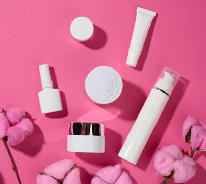Jar and empty white plastic tubes for cosmetics on a pink background. Pack... Stock Photos