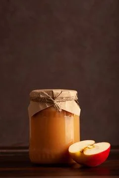 Jar of apple jam with apple slice on dark wooden table Stock Photos