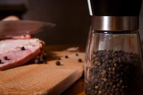 A jar with black pepper on the background of a ham Stock Photos