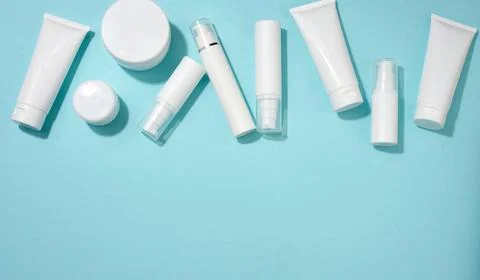 Jar, bottle and empty white plastic tubes for cosmetics on a blue backgrou... Stock Photos