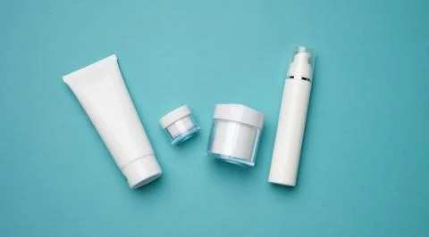 Jar, bottle and empty white plastic tubes for cosmetics on a blue backgroun.. Stock Photos