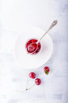 Jar of cherry jam and some cherries on the table Stock Photos