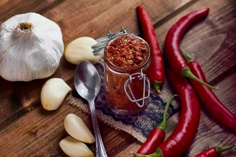 A jar of chilli paste surrounded by ingredients Stock Photos
