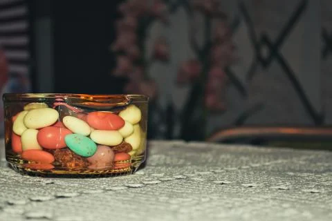 A jar of chocolate almonds on a table Stock Photos