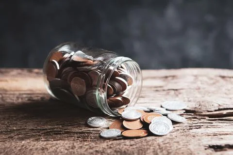 Jar of coins on the table Stock Photos