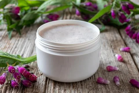 A jar of comfrey root ointment with fresh symphytum plant Stock Photos