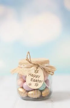 Jar with Easter chocolate eggs on a white wooden table. Foto stock