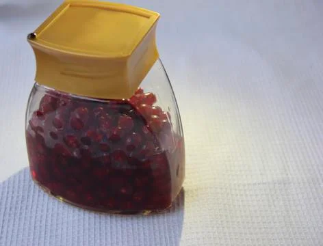 Jar with an elixir or tincture with cranberry berries on a white background, a Stock Photos