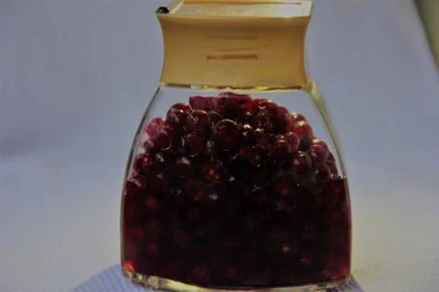 Jar with an elixir or tincture with cranberry berries on a white background, a Stock Photos