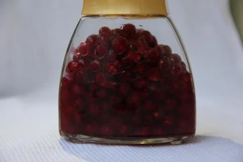 Jar with an elixir or tincture with cranberry berries on a white background, a Stock Photos