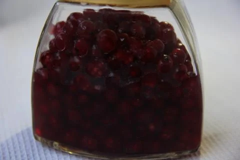 Jar with an elixir or tincture with cranberry berries on a white background, a Stock Photos