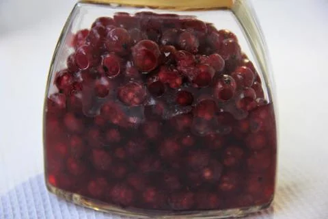 Jar with an elixir or tincture with cranberry berries on a white background, a Stock Photos