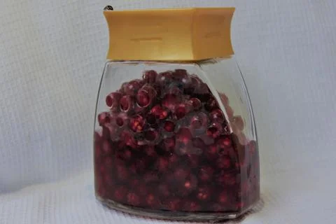 Jar with an elixir or tincture with cranberry berries on a white background, a Stock Photos